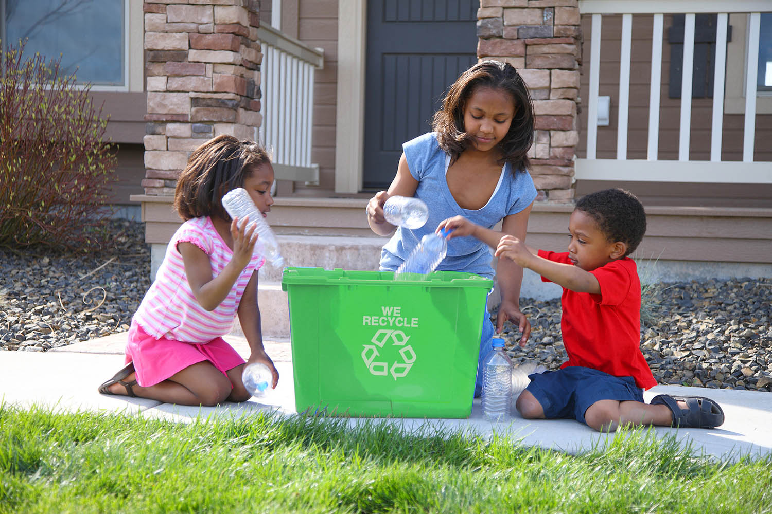 Woman and two children recycling