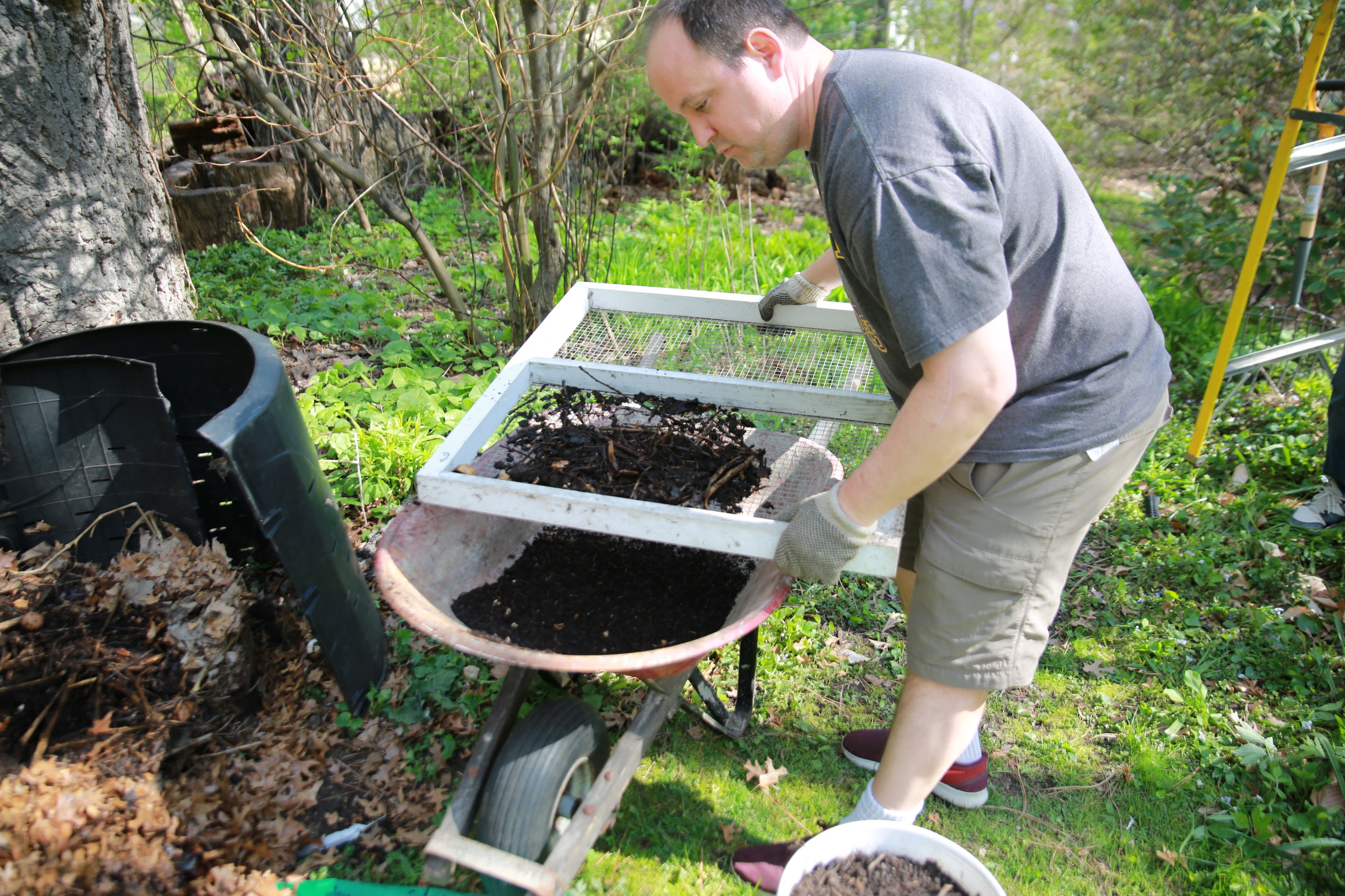 Sifting finished compost with a screen. 