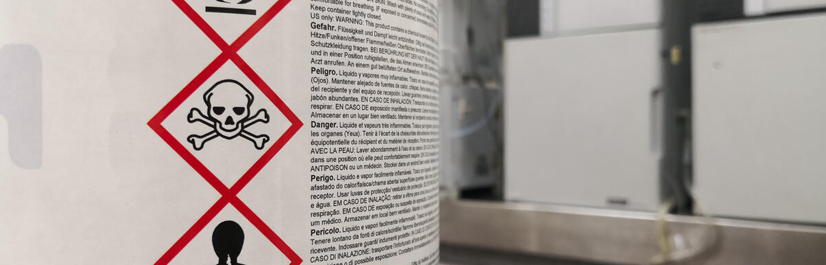 Hazard symbols on a chemical container label in a laboratory setting.