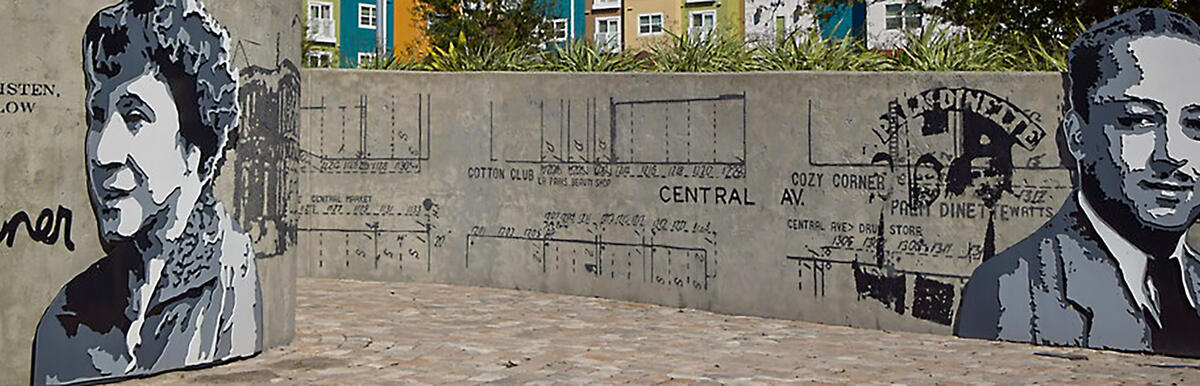 Mural featuring two monochrome portraits on a wall with abstract designs.