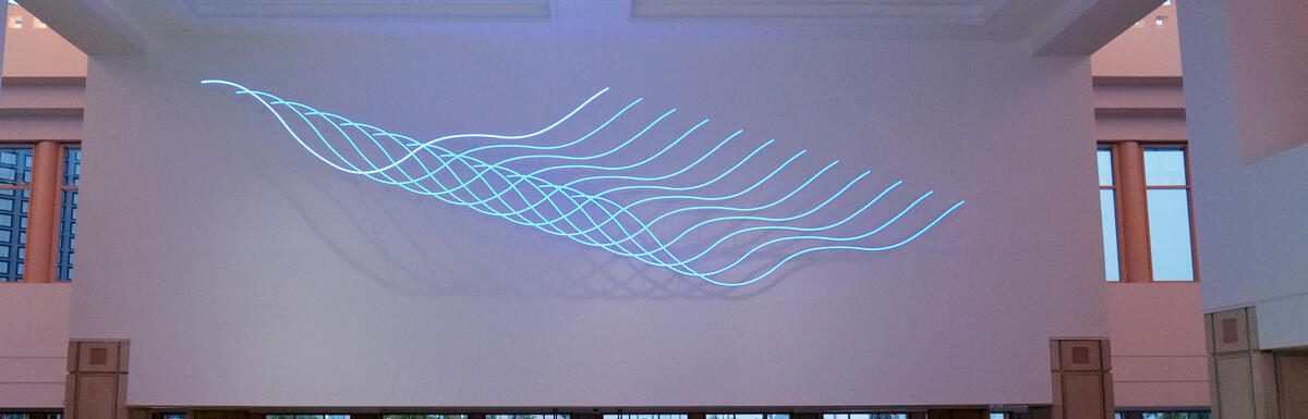 Lobby with geometric floor pattern and a Luftwerk light installation projected on the wall.
