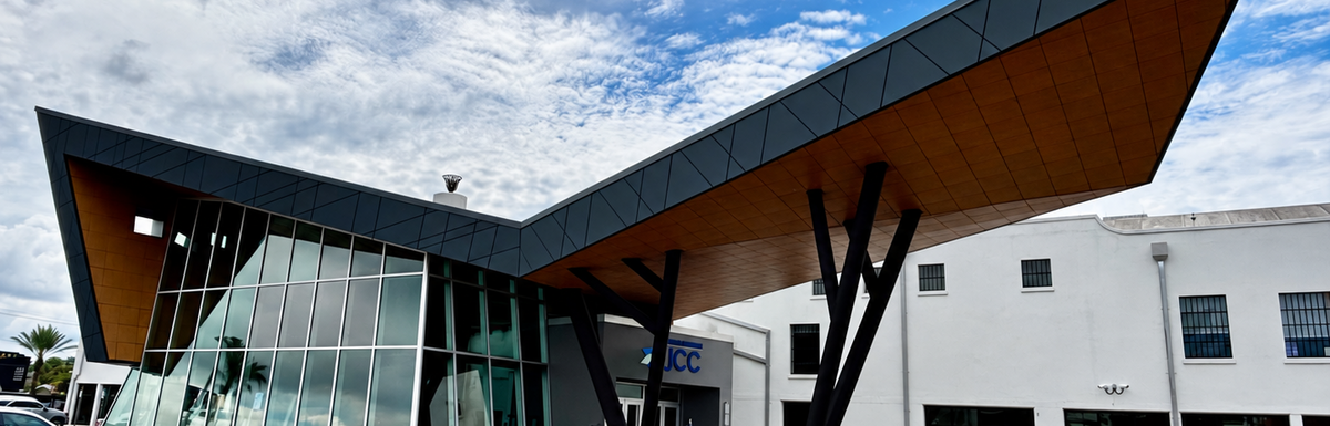 Modern Golding building exterior with dramatic angular roof and glass facade under a cloudy sky.