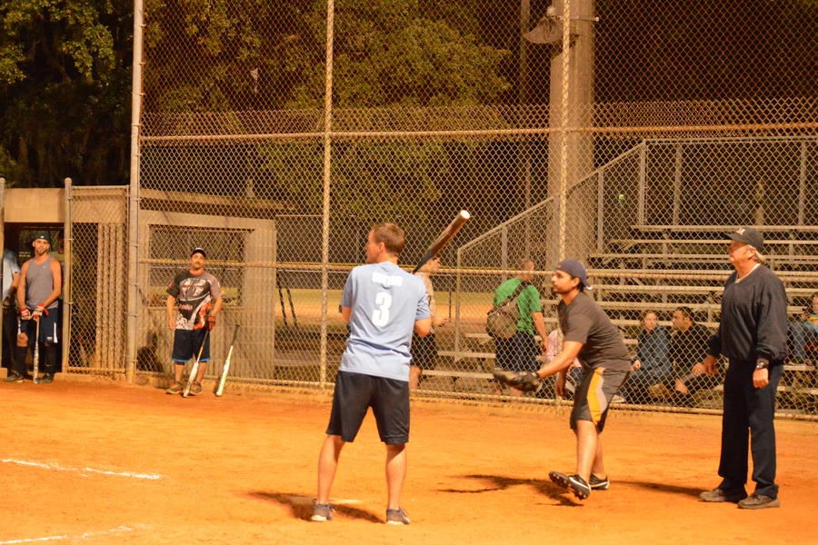 Batter in mid swing with umpire and catcher in their respective positions.