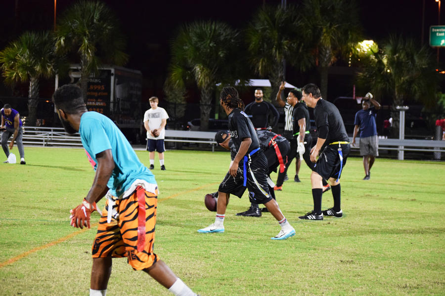 Players lined up to being play in a traditional flag football line up