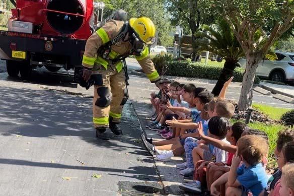 Firefighter high-fiving kids