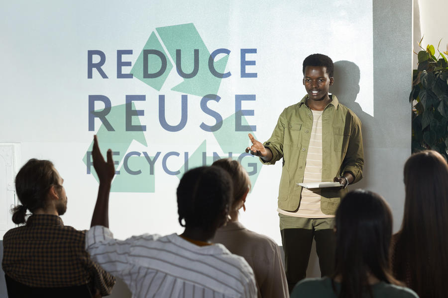 Person standing in front of a crowd presenting on recycling