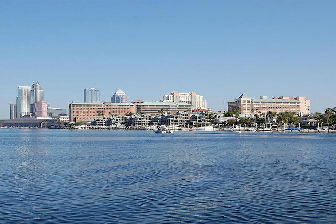 City skyline and waterfront under a clear blue sky, indicating sea-level rise impact.