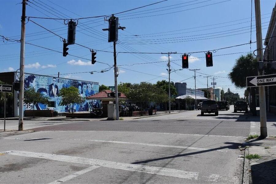 Intersection in neighborhood commercial district with traffic lights and mural.