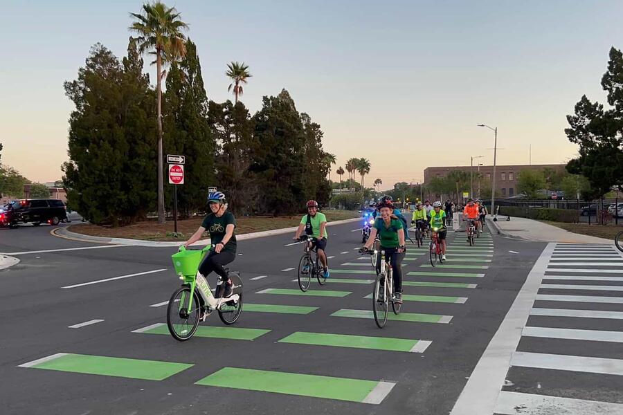 Cyclists ride in a group on a city street