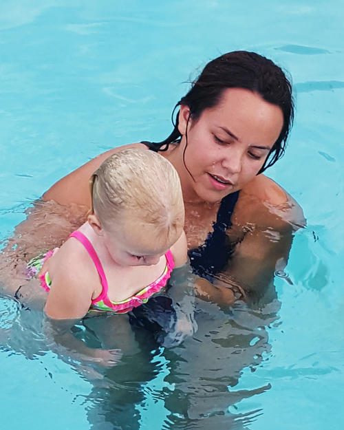 Instructor holding small child in the water