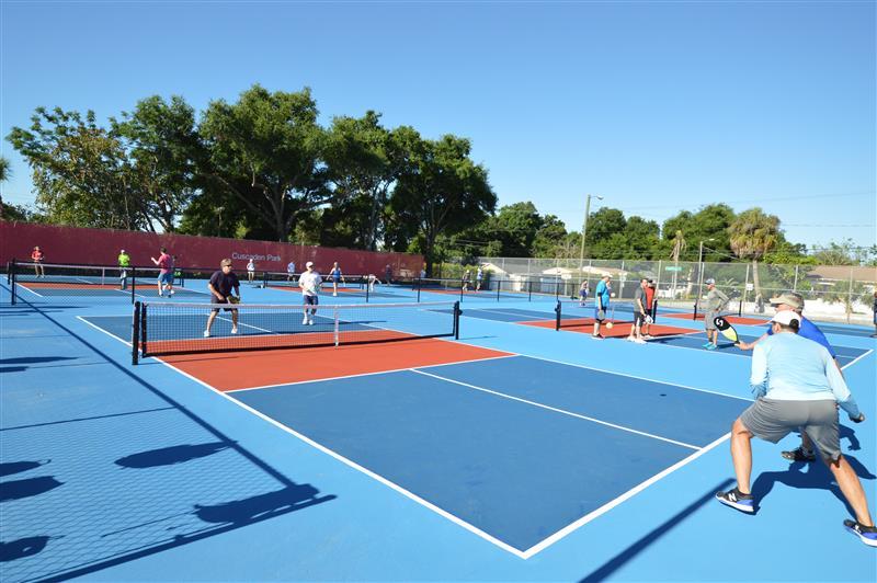 Corner image of outdoor pickleball court with people in play