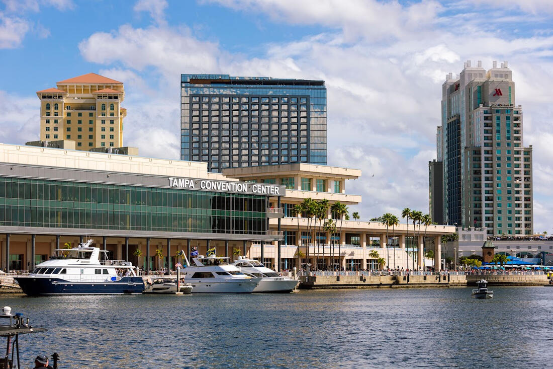Tampa Convention Center marina with boats and city skyline in the background.