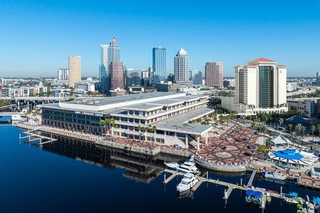 Aerial view of a waterfront cityscape of Tampa with the Tampa Convention Center and a prominent new embassy building.