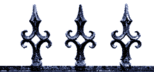 Decorative wrought iron cemetery gates with pointed finials.