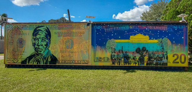 Colorful mural resembling cultural-themed currency, featuring historical figures and scenes.
