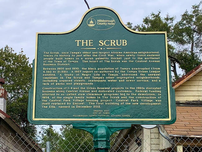 Historic marker titled &quot;The Scrub&quot; detailing local history and notable events in green text.