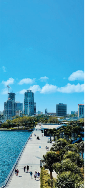 City skyline and waterfront promenade under clear sky