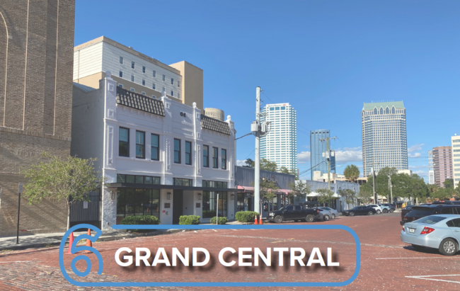 Grand Central area with buildings and parked cars under a clear blue sky.