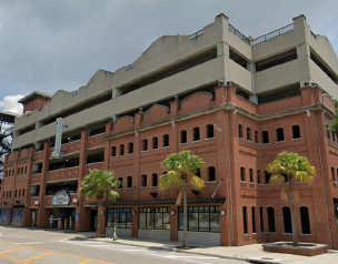 Large brick and concrete parking structure under an overcast sky.