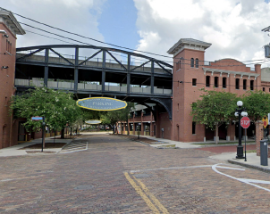 Historic district with brick buildings and street, under a cloudy sky.