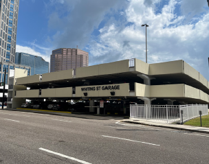 Parking garage under a partly cloudy sky.