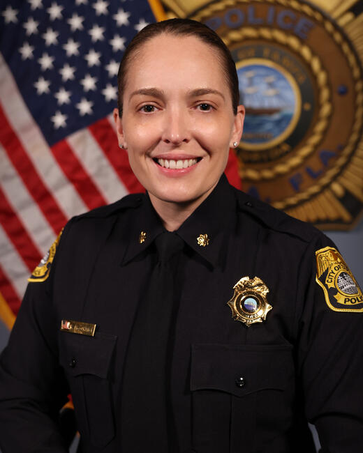 Major McCormick in uniform, American flag and police emblem in background.