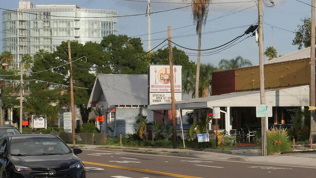 Neighborhood commercial district with shops and signage in Palma Ceia.