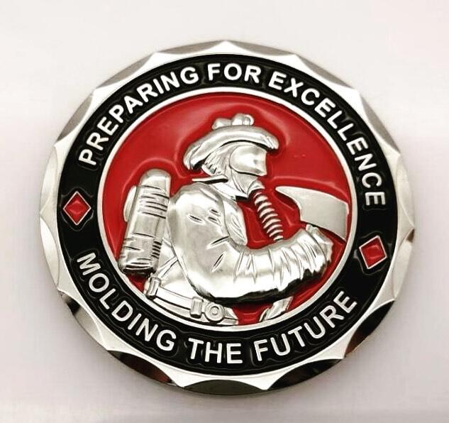 Metal challenge coin featuring a firefighter cadet and the text "Preparing for Excellence, Molding the Future."