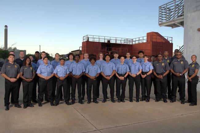Group of uniformed cadets posing for a main group photo outdoors at the TFR training center.