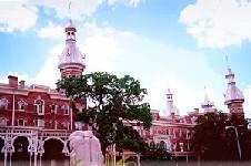 Historic red-brick University of Tampa building with domed towers and palm trees.