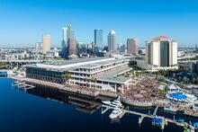 Aerial photo of Tampa Convention Center on a waterfront marina with hotel and skyline in the background