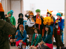Group of cosplayers in colorful costumes posing at a convention, Metrocon 2025 setting.