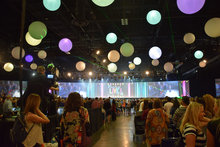 Crowd gathers in the main exhibit hall for Juice Plus Live while colorful decorative orbs hang overhead. 