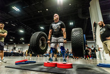 Man powerlifting with two tires as weights