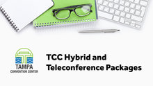 Photo of a white desk with a keyboard glasses and notebook with words TCC Hybrid and Teleconference Packages