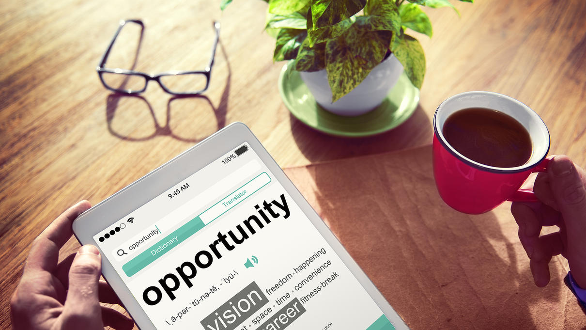 Hands holding a tablet with the words "Opportunity"